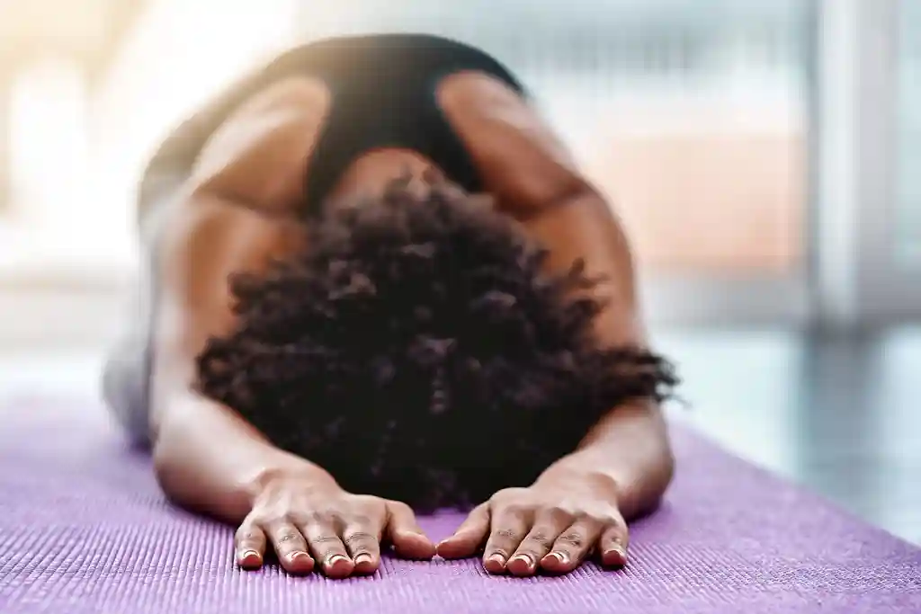photo of woman holding yoga pose on mat